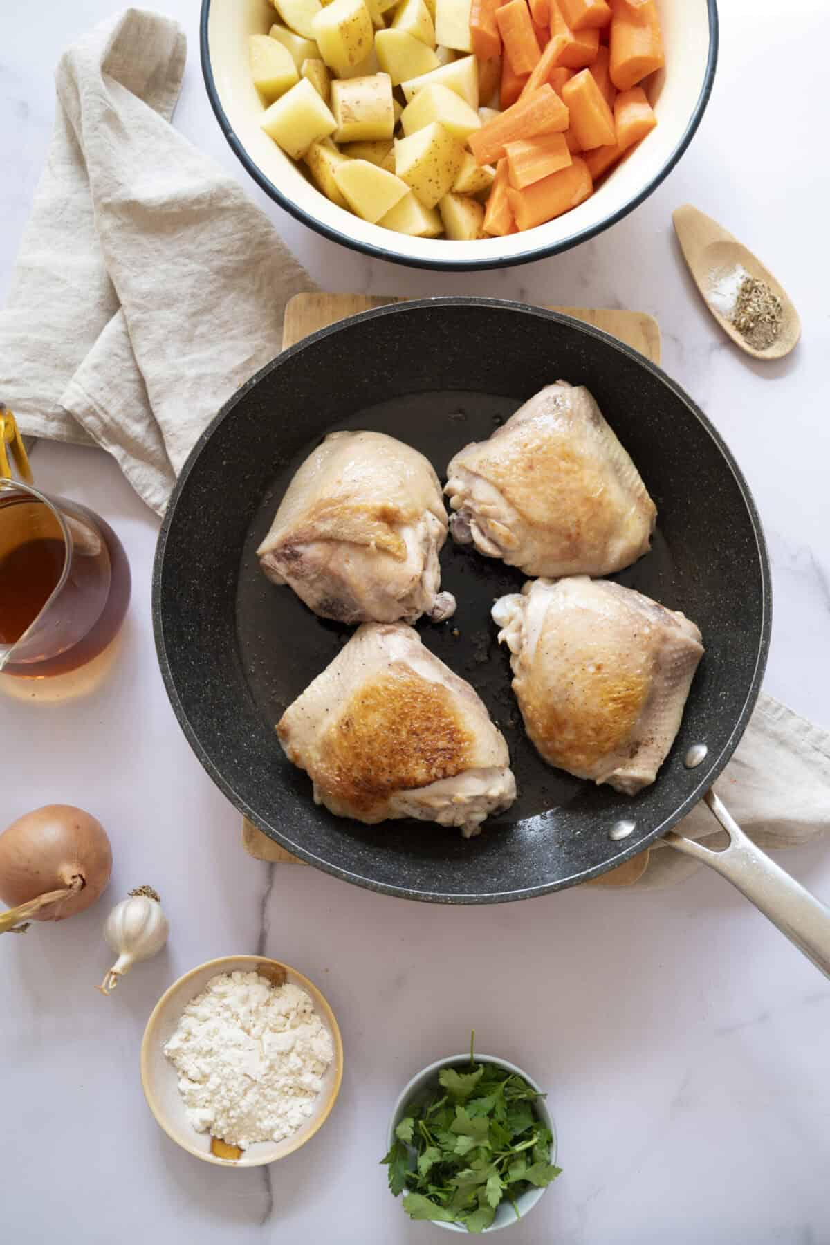 A pan of browned chicken thighs.