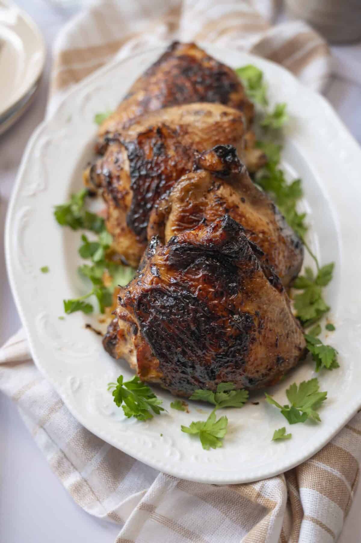 Juicy grilled bone-in chicken thighs framed by parsley sprigs.