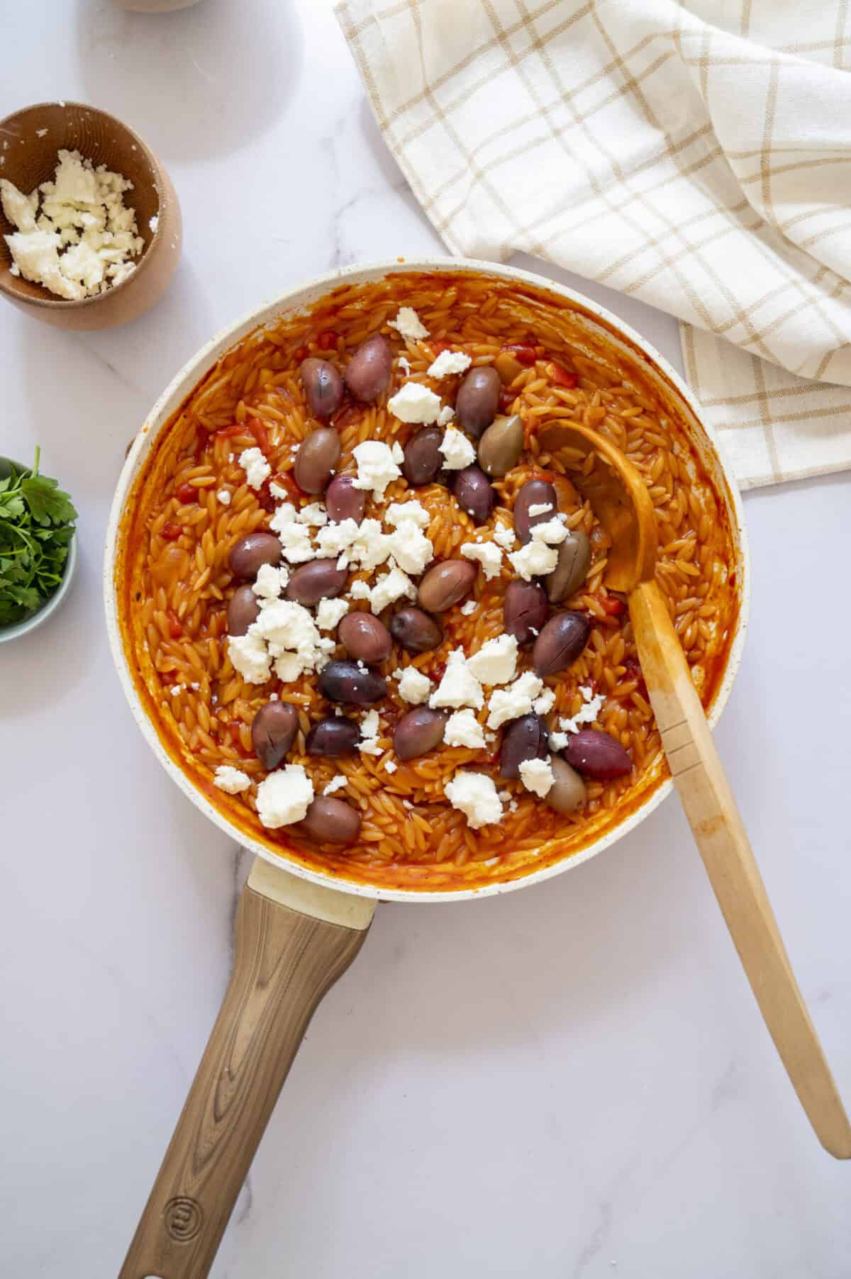 A pan of orzo with olives and feta.