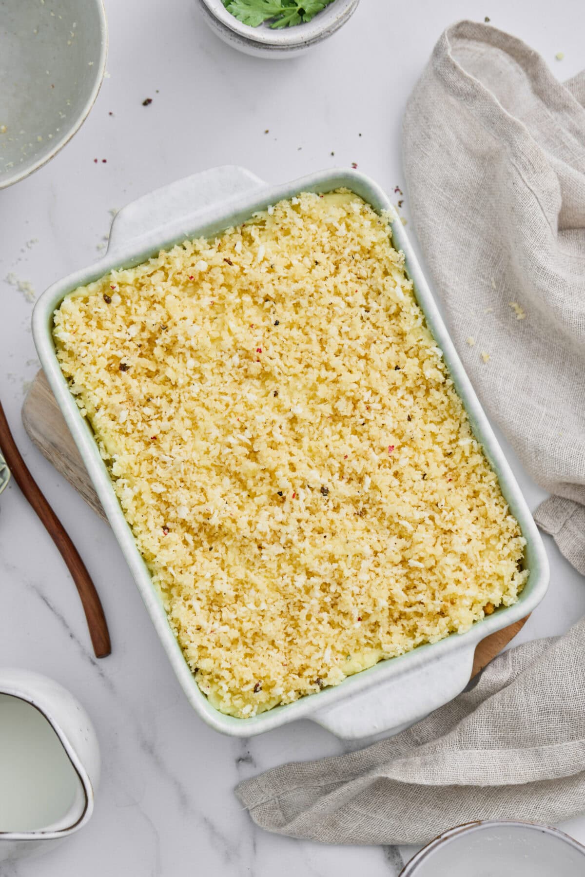 A casserole dish of mashed potatoes with a panko topping.