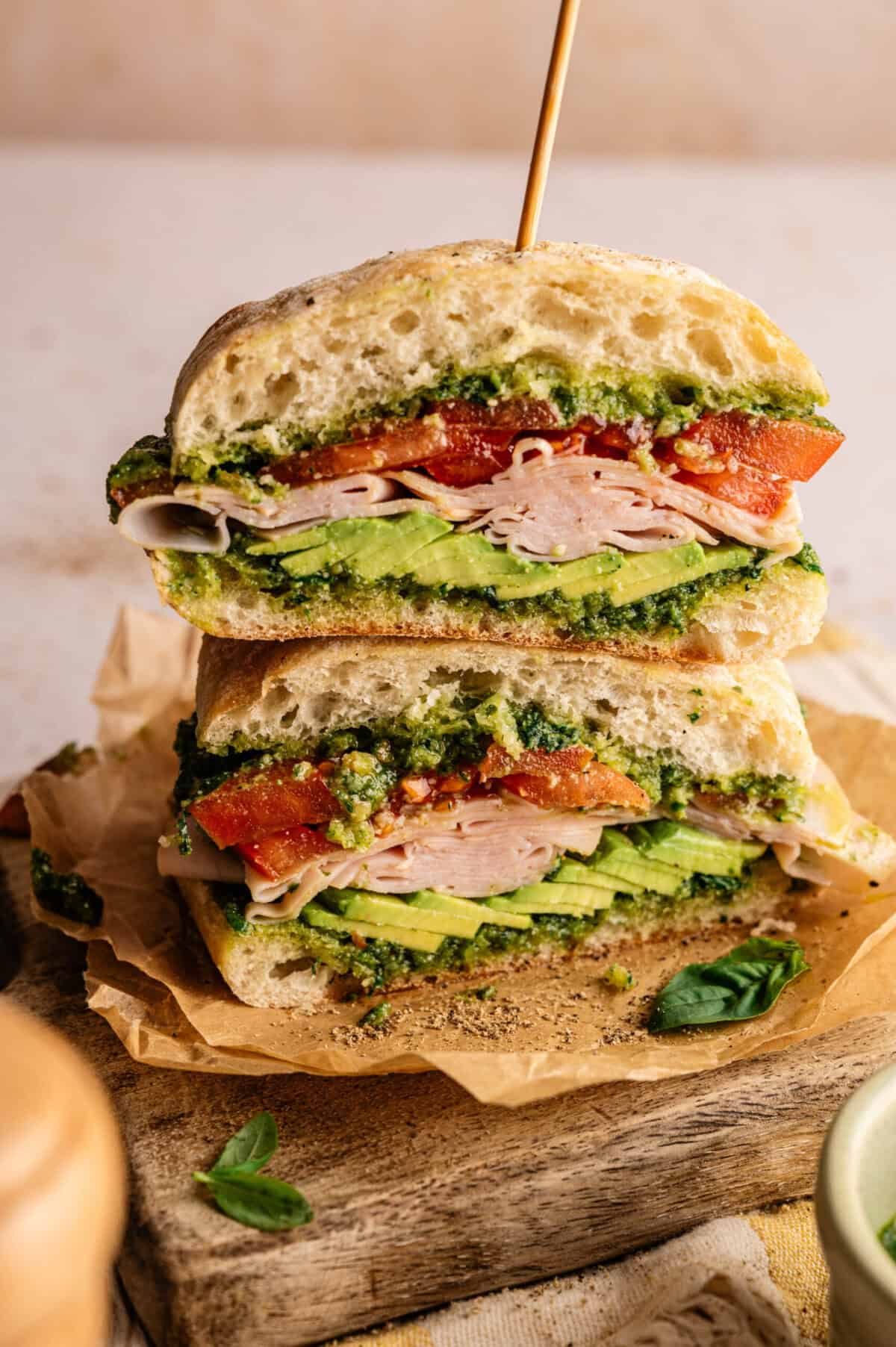 A smoked turkey sandwich sliced in half.