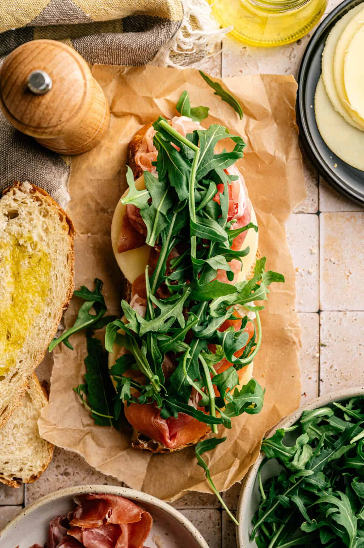 A slice of bread topped with prosciutto and arugula.