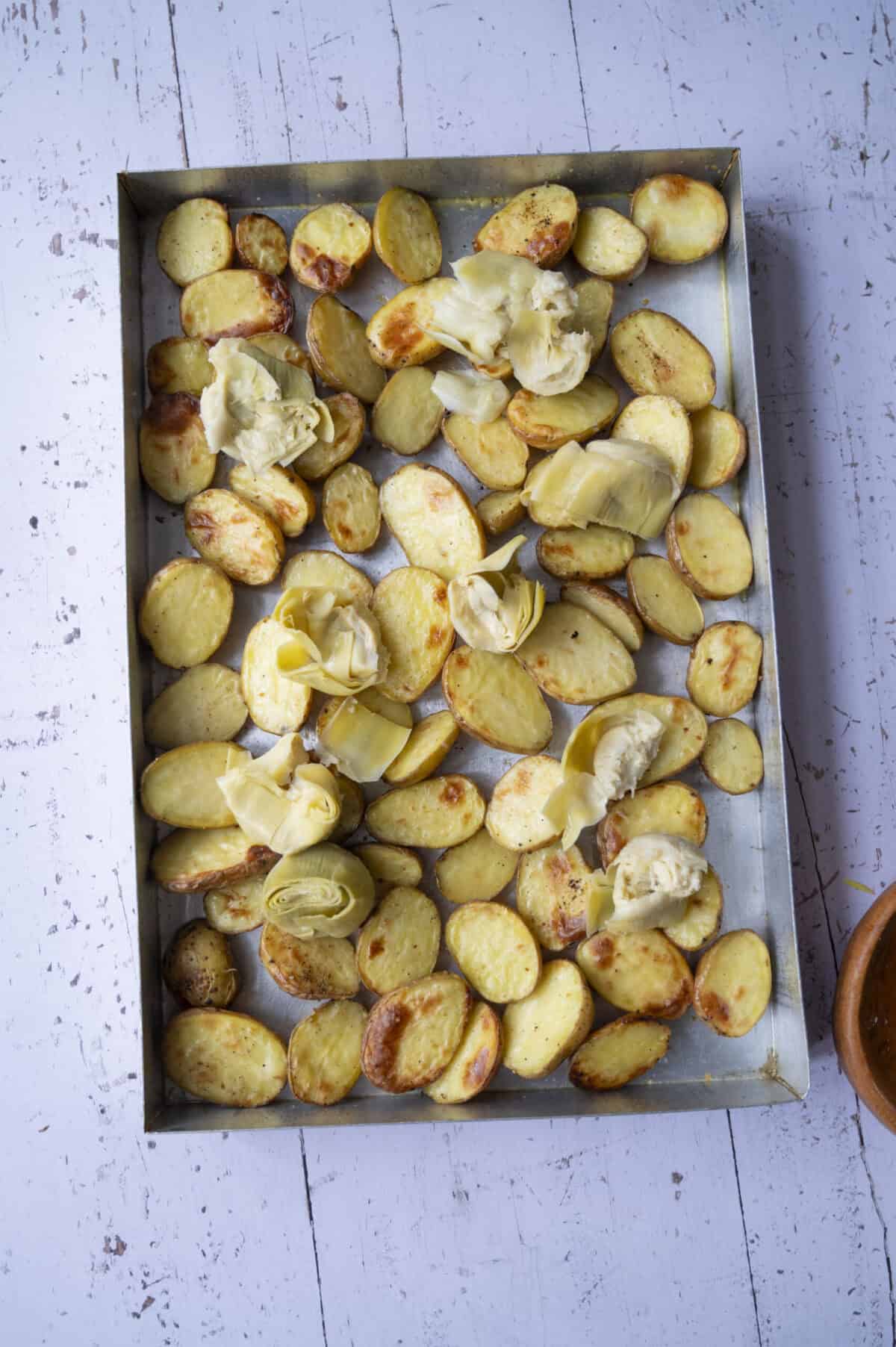 A pan of baked baby potatoes and artichoke hearts.