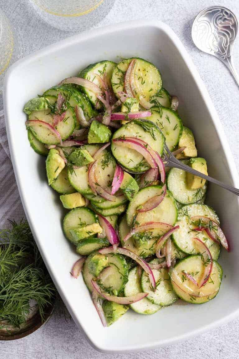 A cucumber salad dressed with dill, red onion, and avocado.