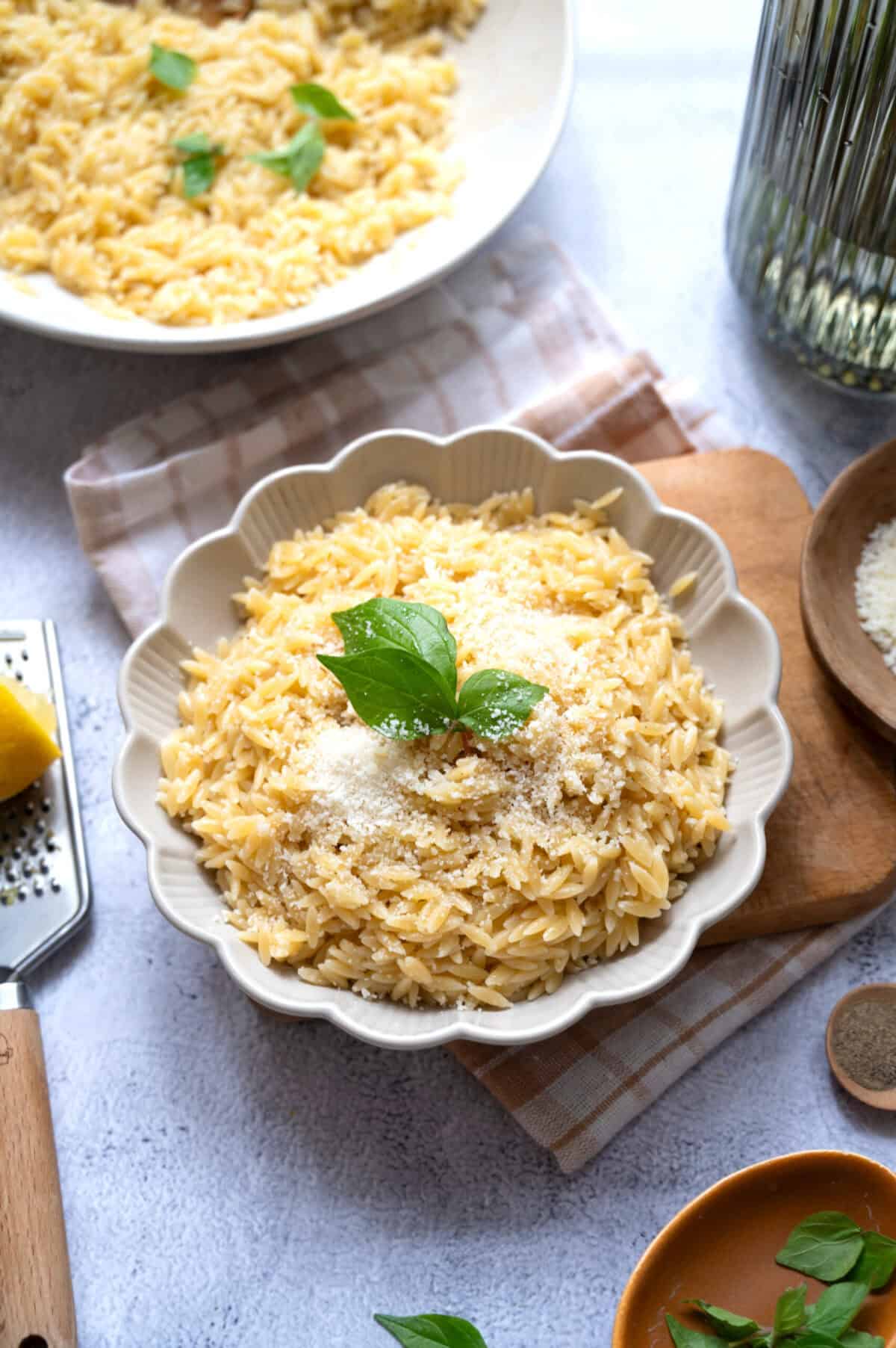A bowl of lemon orzo with basil sprigs.