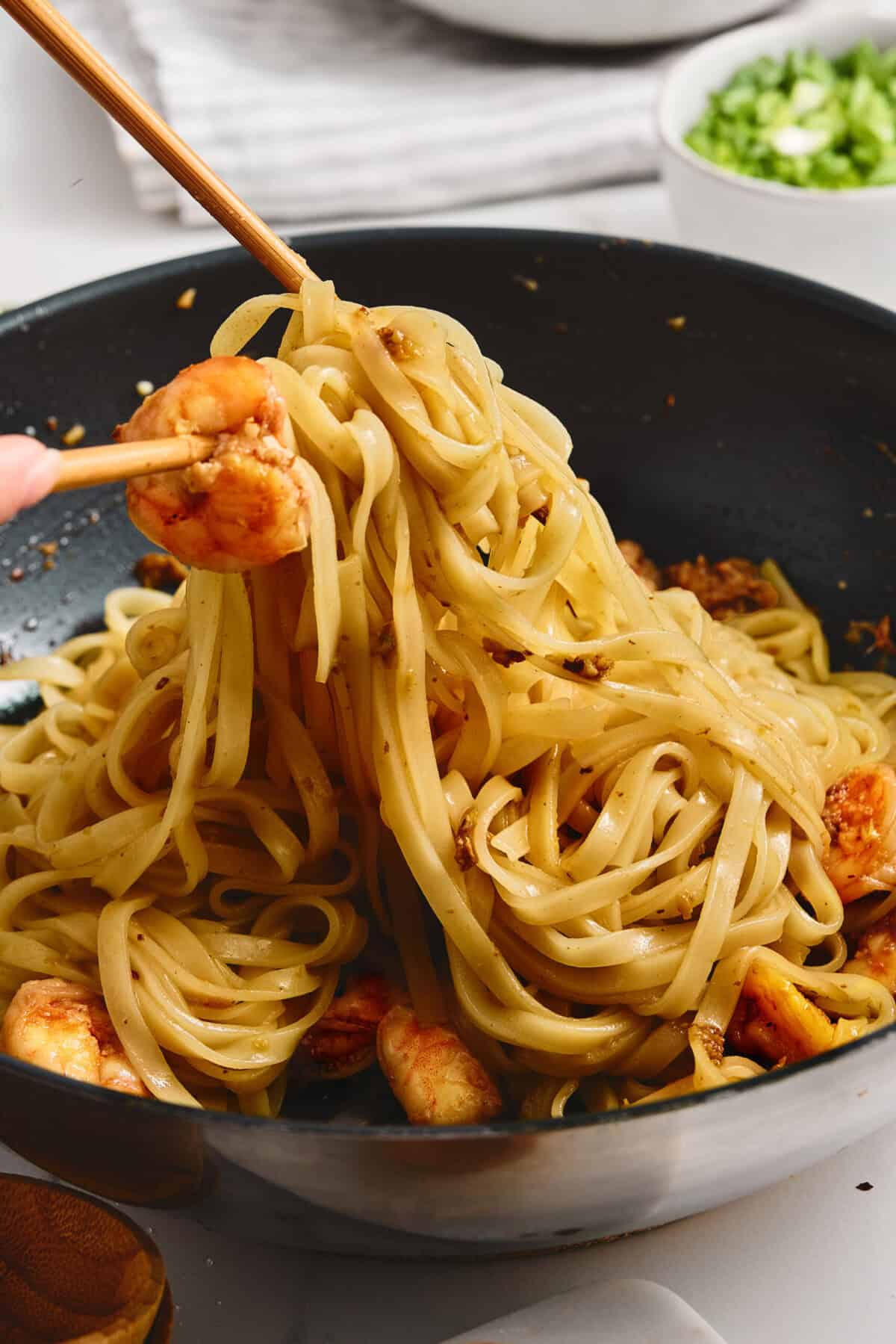 A pan of rice noodles tossed with shrimp.