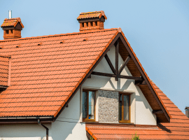 Close-up of a house roof with orange tiles and chimneys