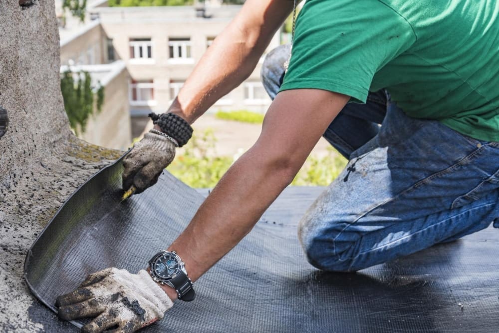 Person installing roofing material on a flat roof