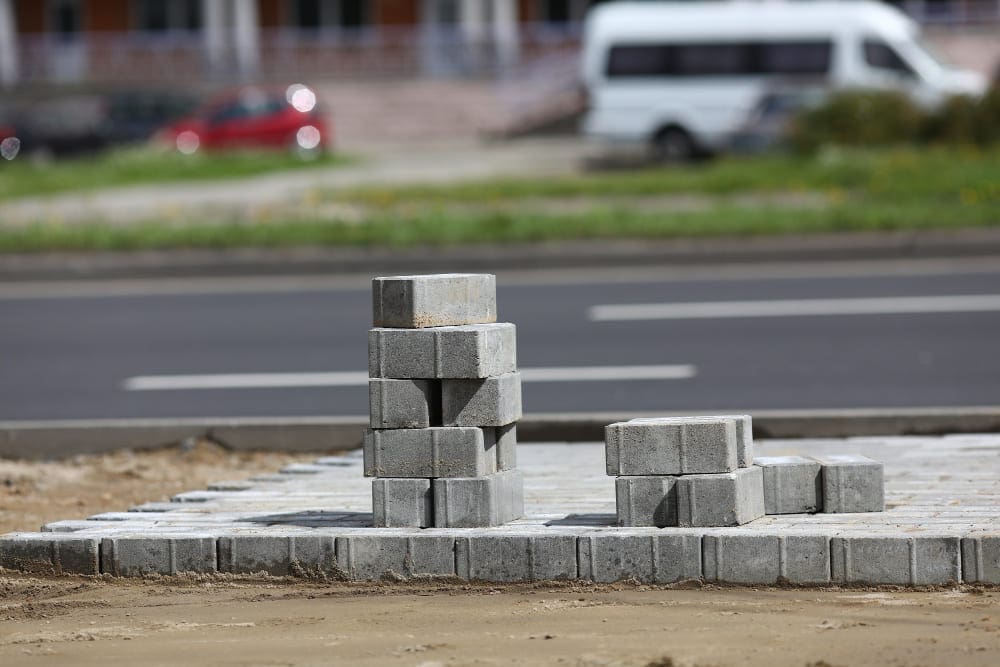 Stacked grey paving stones on a sidewalk under construction