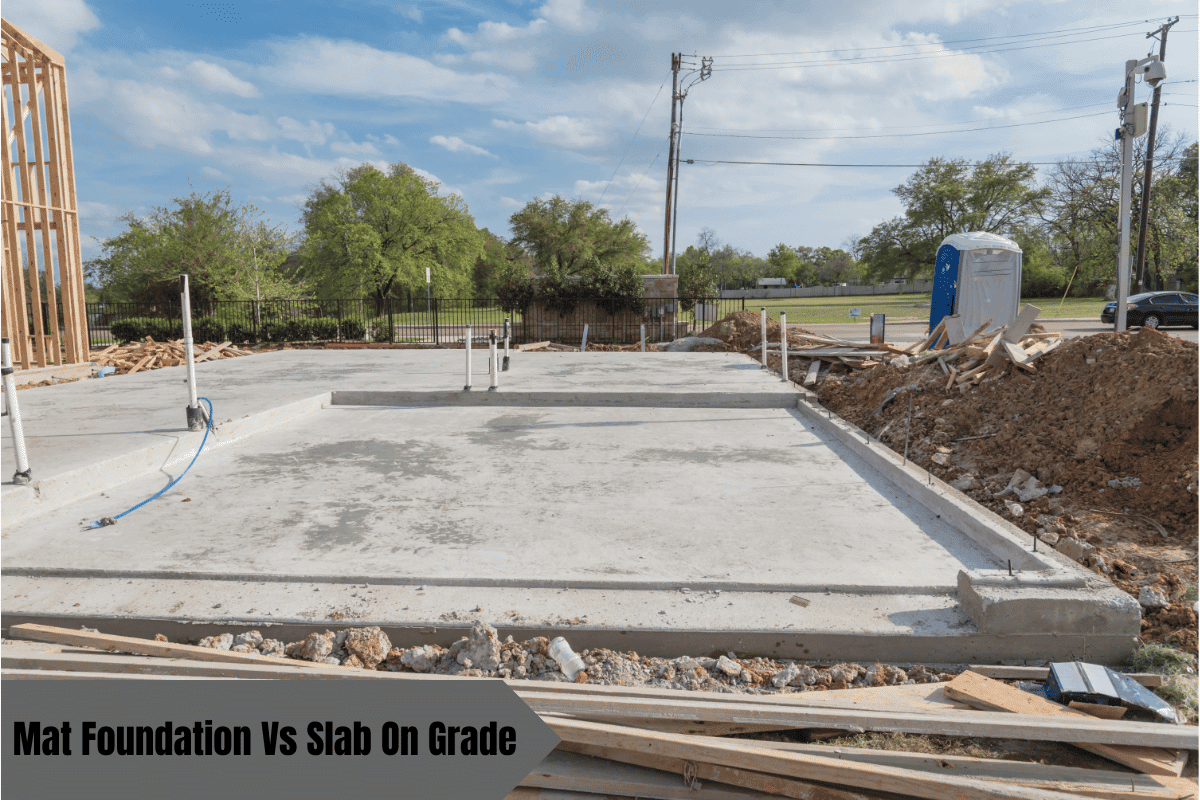 Concrete slab foundation on a construction site with a portable toilet.