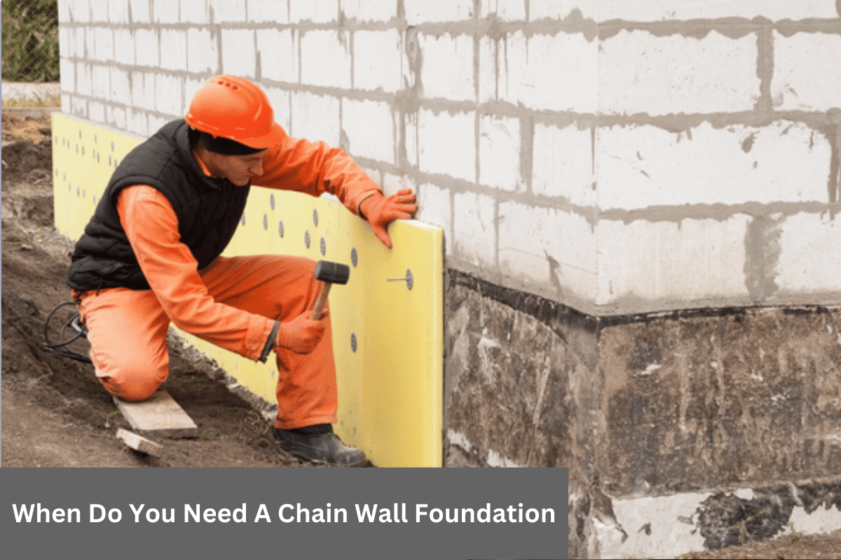 Worker installing yellow insulation on a building foundation