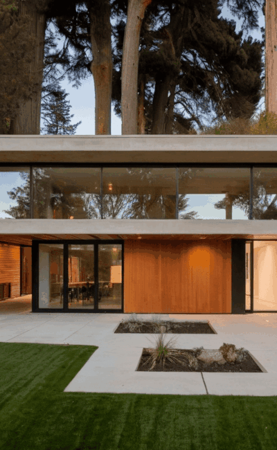 Modern concrete and wood house with large windows and lawn