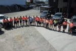 Team of construction workers and supervisors standing in a line at a building site in New Zealand.