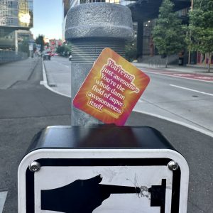 Pocketful of Zen card wedged between a pole and a crosswalk sign. Text reads: You're not just awesome, you're the whole damn field of awesomeness itself.