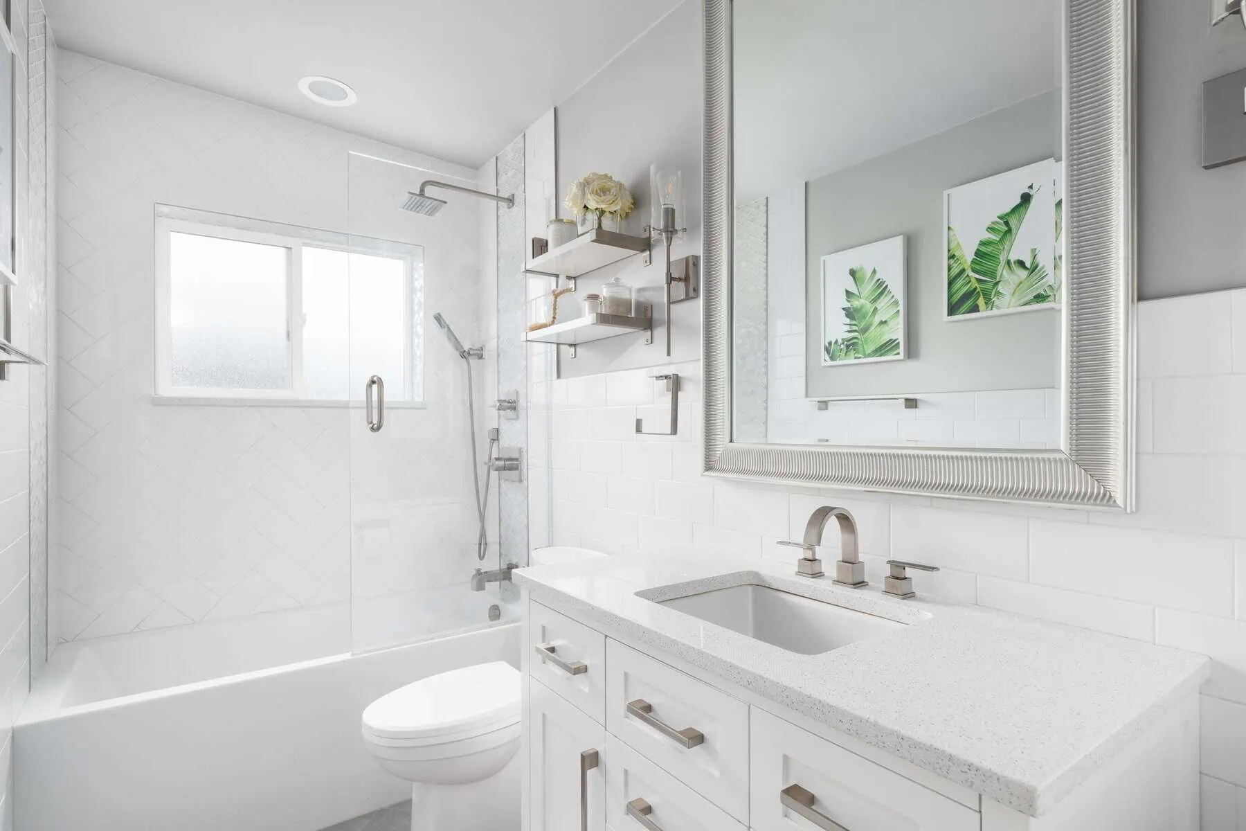 Modern white bathroom with shower, toilet, vanity, and mirror.