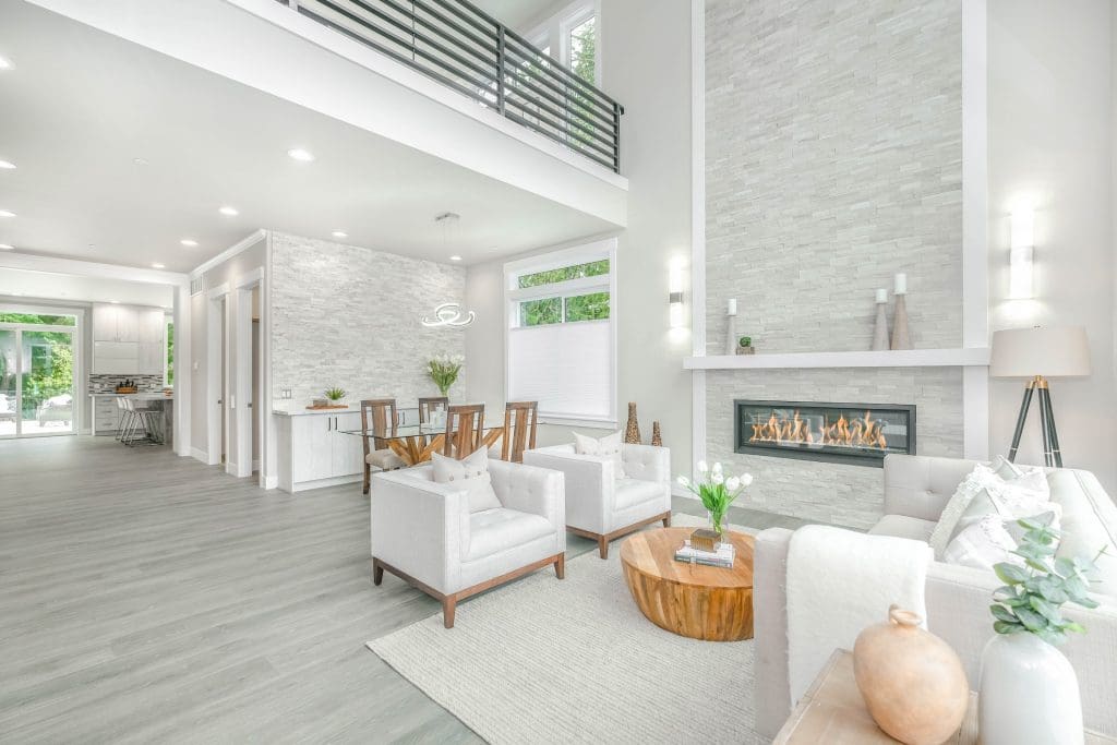 Modern living room with fireplace, white furniture, and dining area.