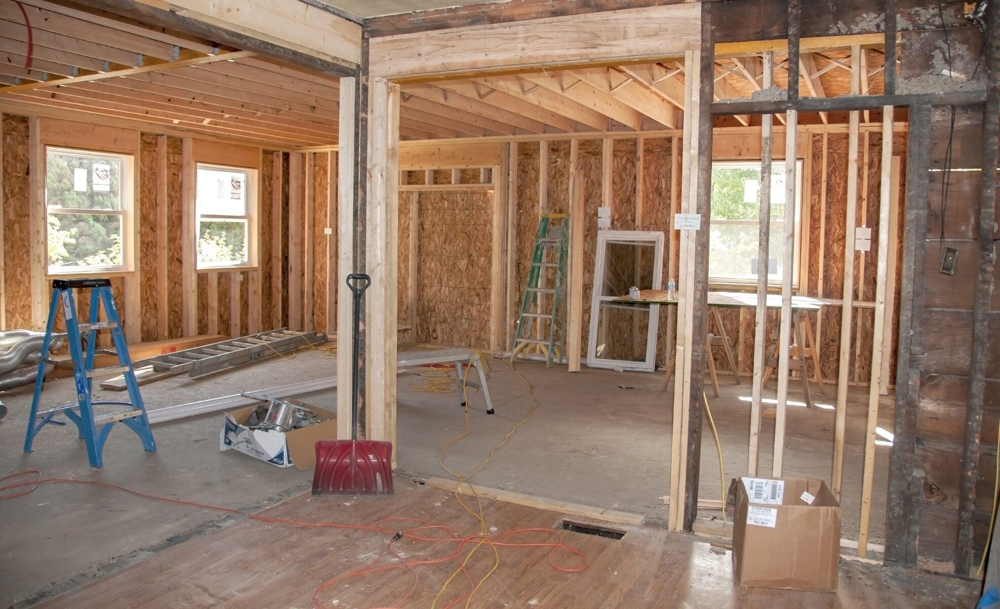 Interior of a house under construction with exposed wooden frames and tools.