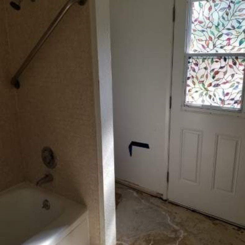 Bathroom with bathtub, shower, and door with stained glass window
