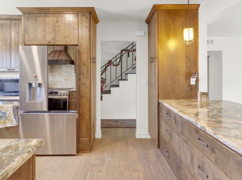 Modern kitchen with stainless steel appliances and wooden cabinets.