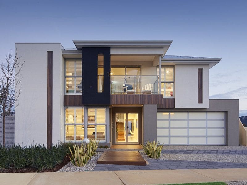 Modern two-story house with a balcony and a garage at dusk.