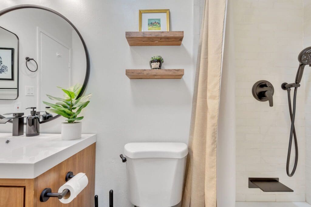 Modern bathroom with white walls, wooden vanity, and black fixtures