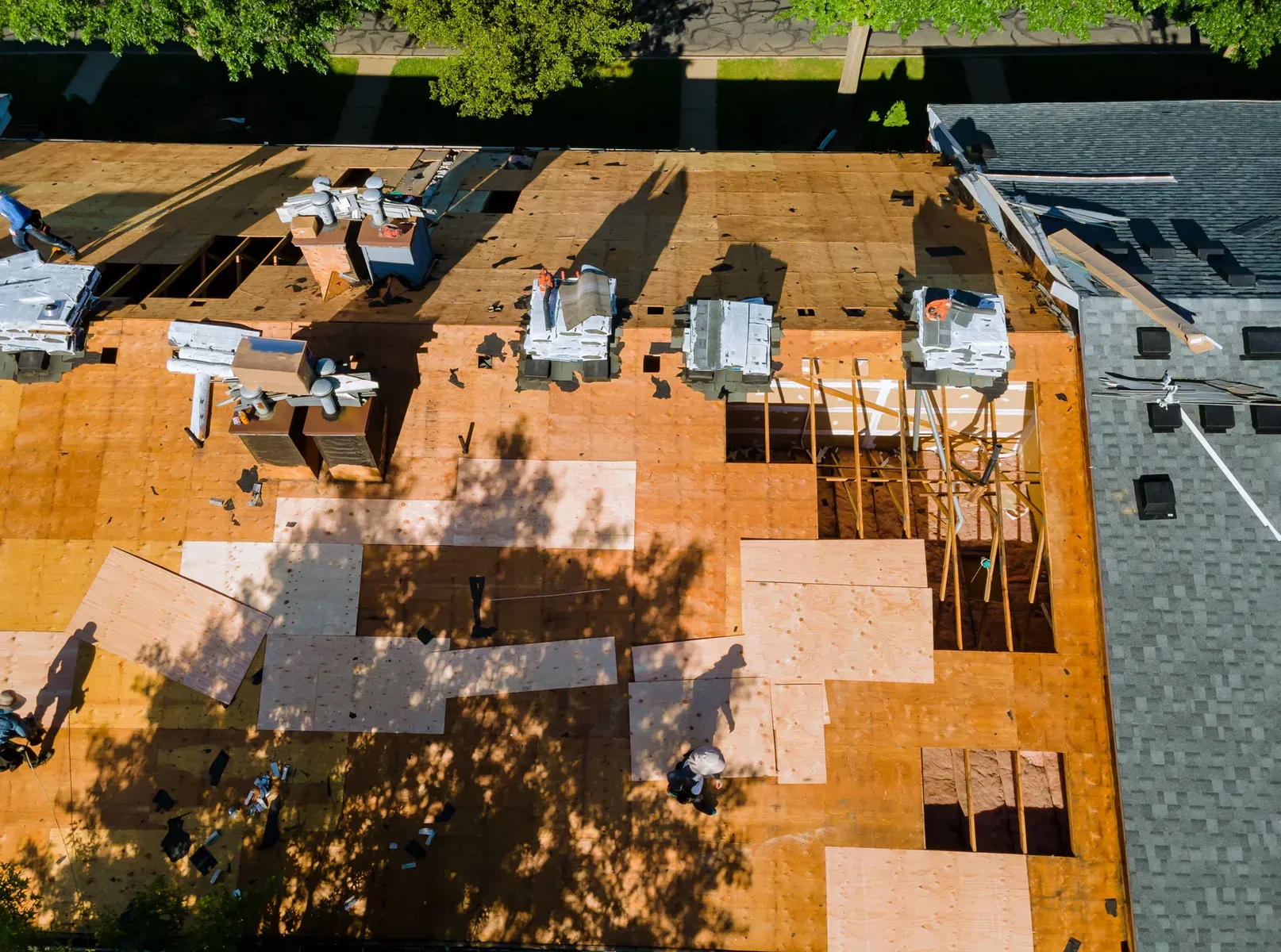 Aerial view of roof replacement in progress on a large building