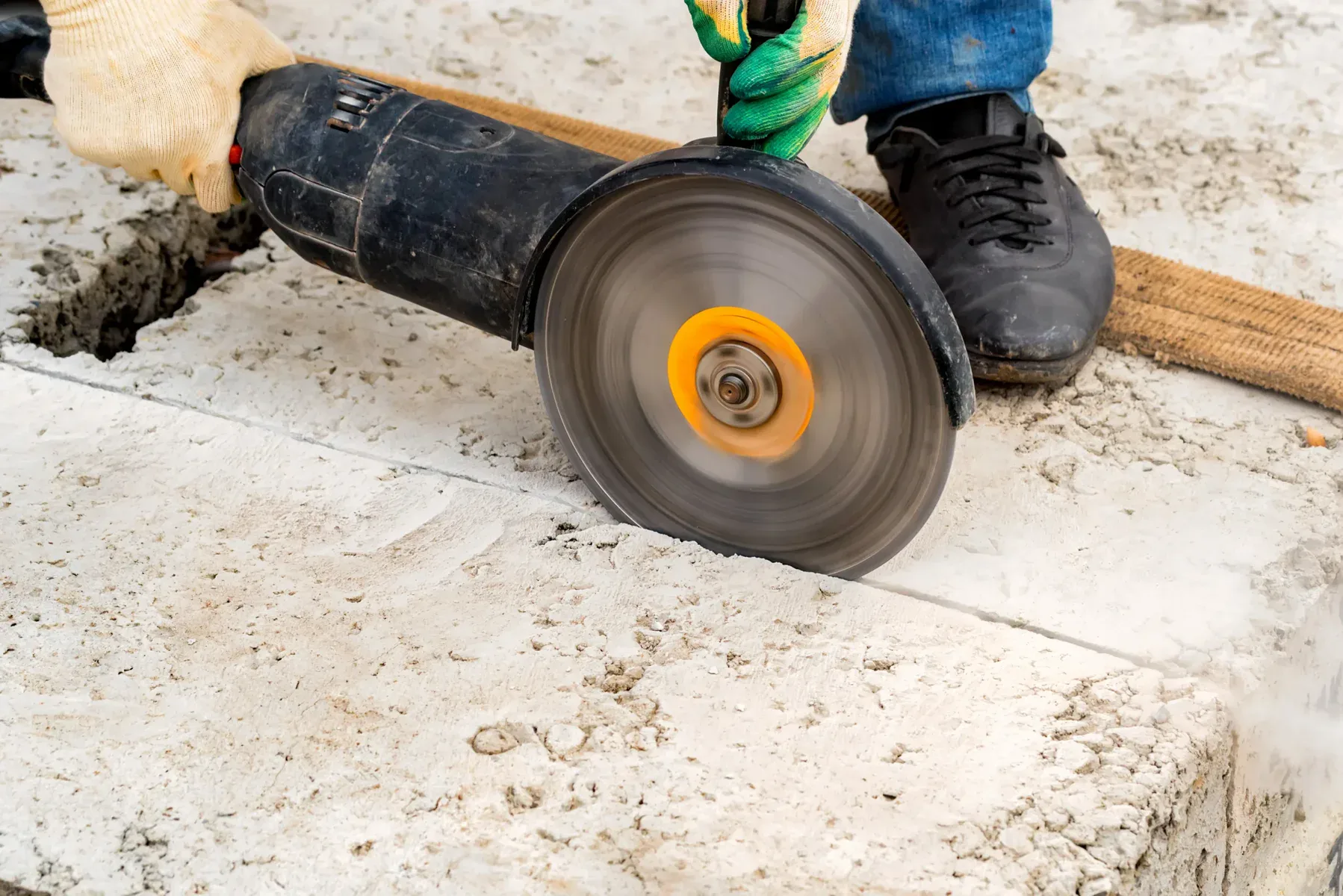 Close-up of a person cutting concrete with an angle grinder