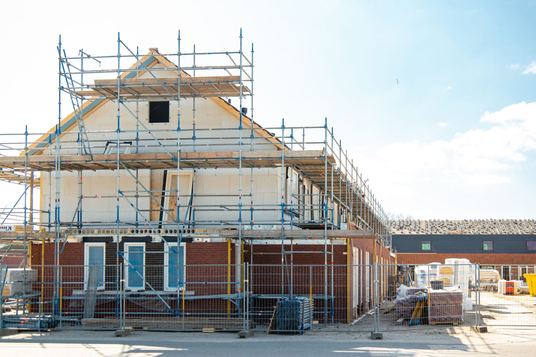 New house under construction with scaffolding and building materials