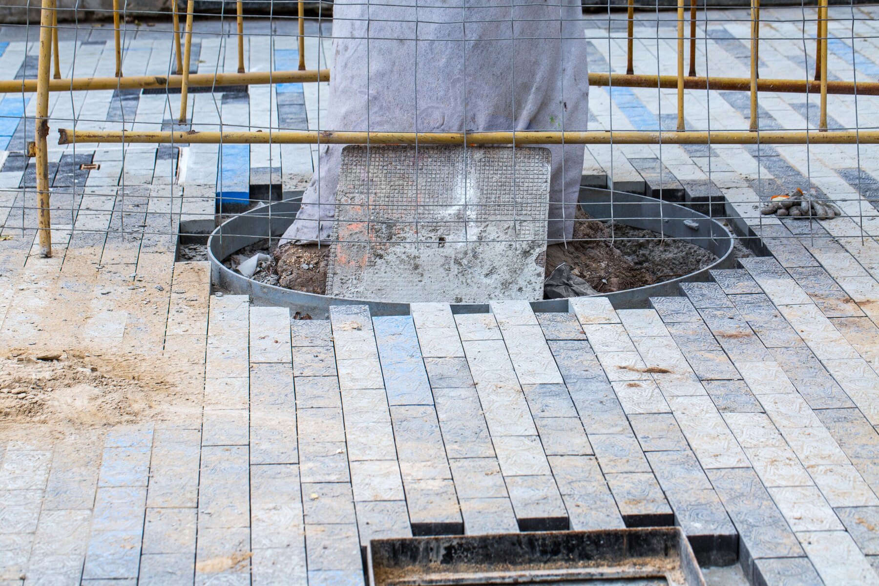 Construction site with paving stones and a metal grate