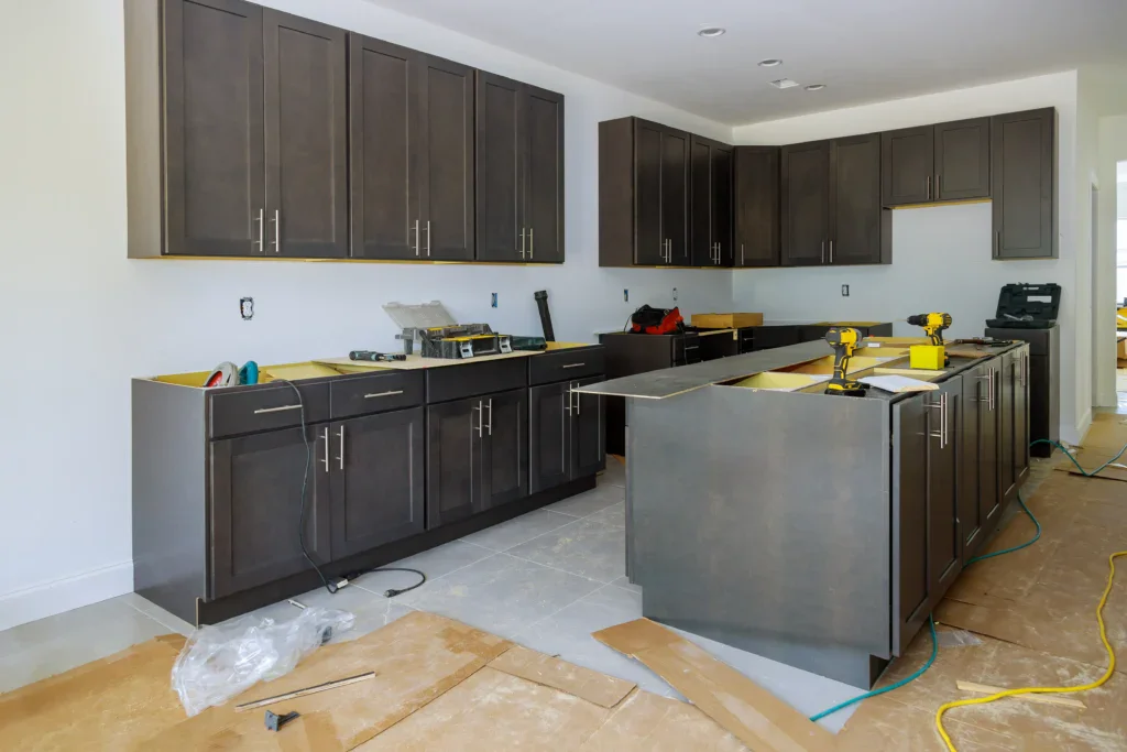 Kitchen under construction with dark cabinets and tools