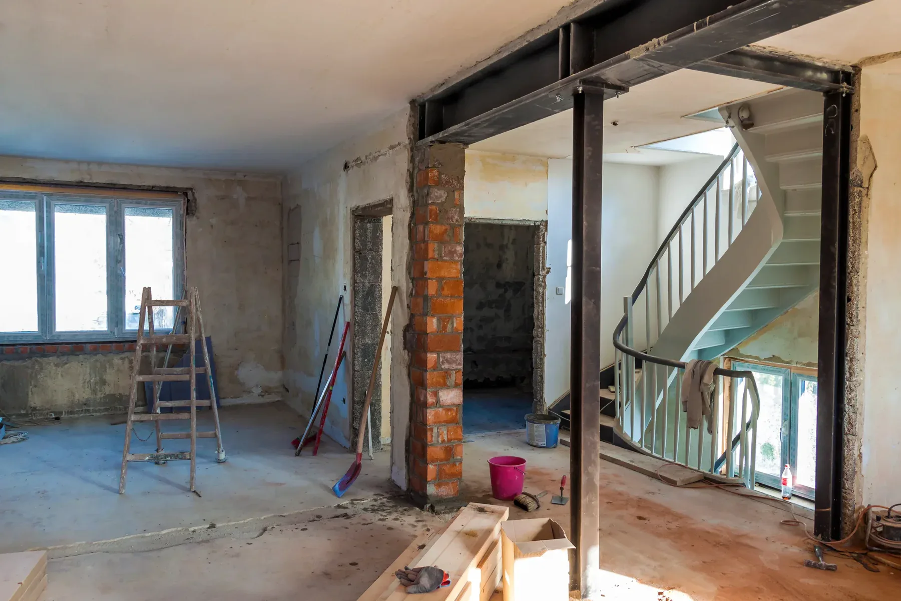 Interior of a house under renovation with exposed brick and metal beams