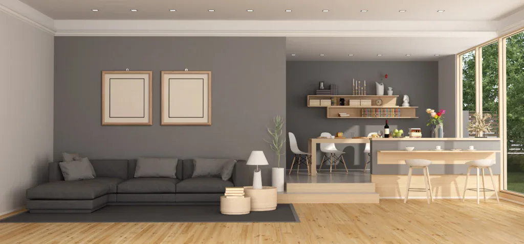 Modern open-plan living space with gray sofa, dining area, and kitchen island