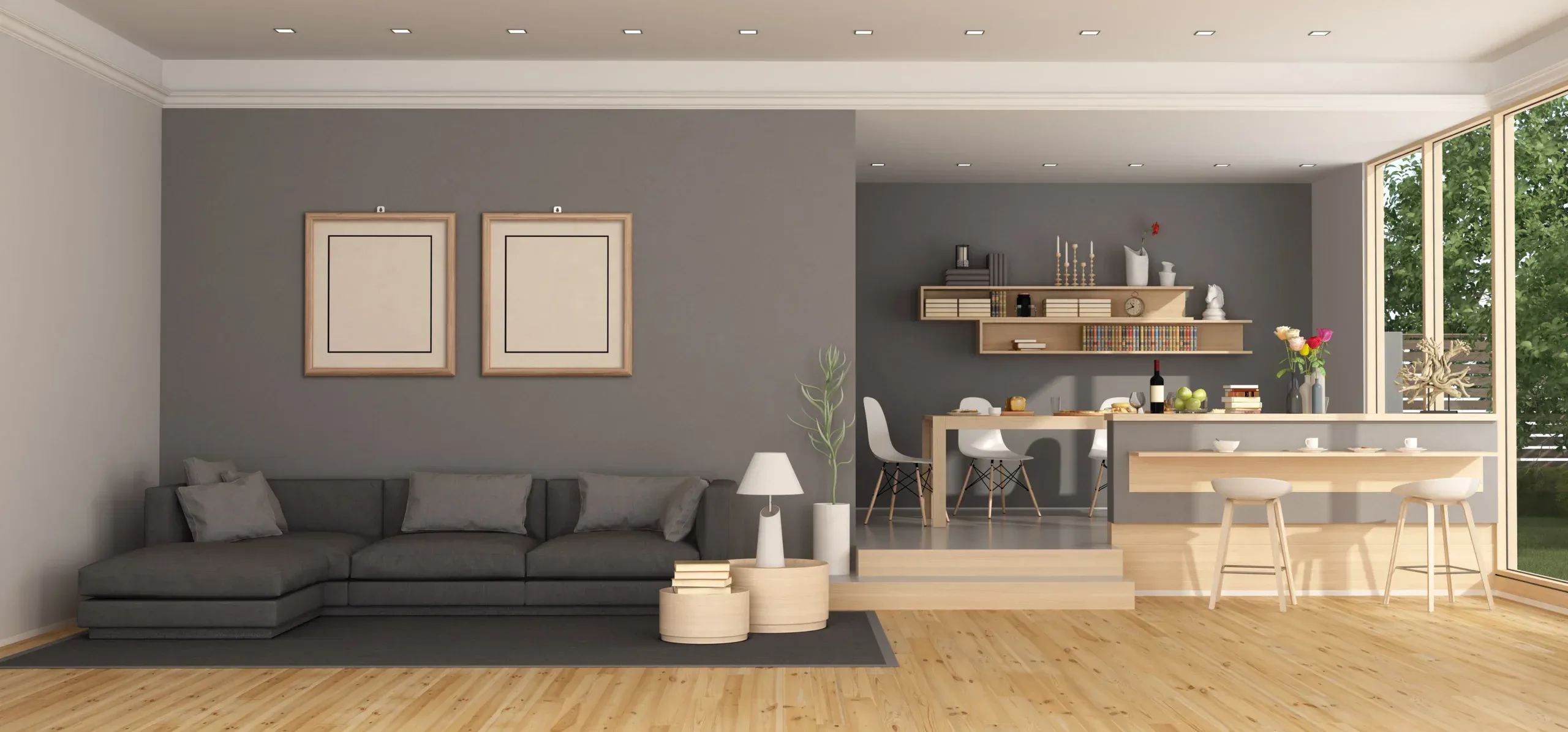 Modern open-plan living space with gray sofa, dining area, and kitchen island