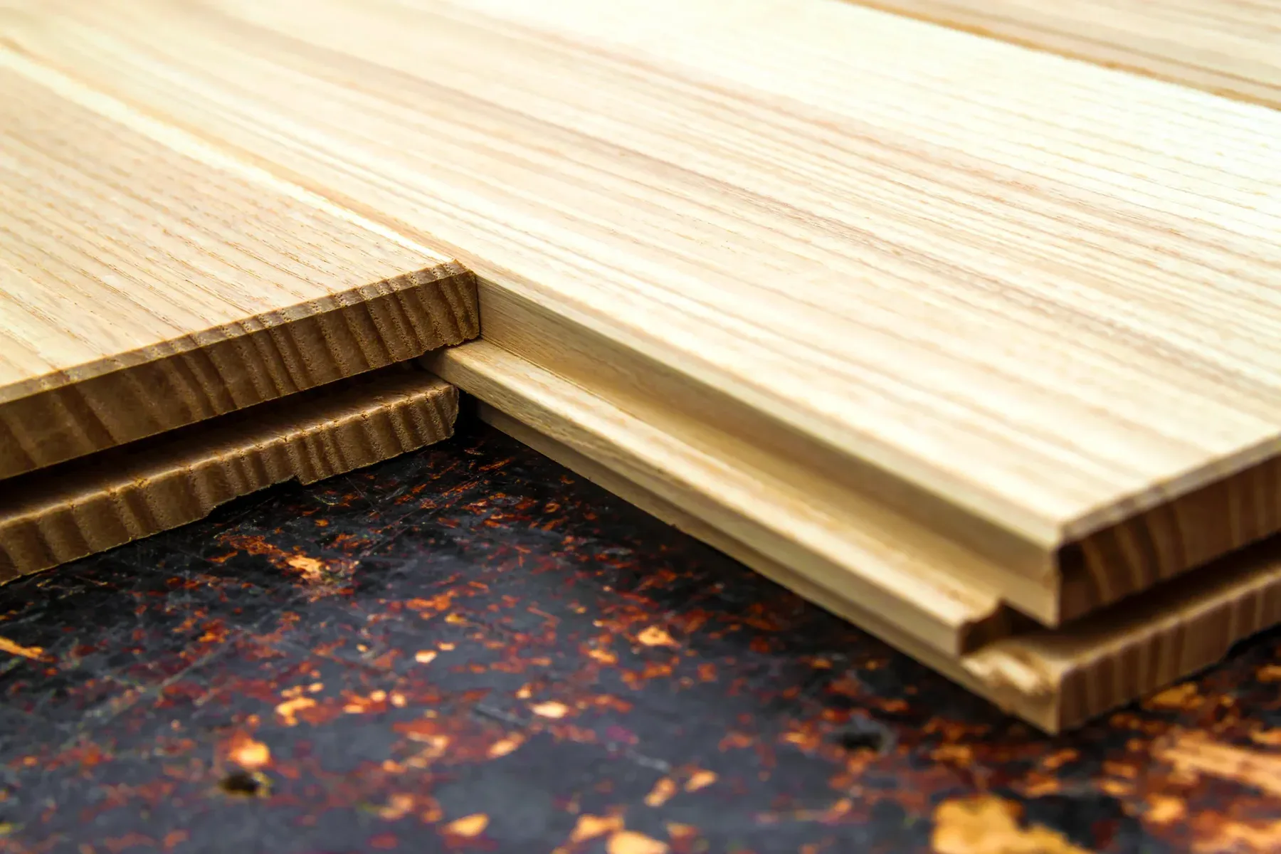 Close-up of unfinished wood flooring planks with tongue and groove joints