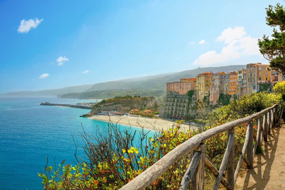 View from the Gardens of the Sanctuary, of Tropeas white sand Rotondo Beach and pastel coloured medieval buildings above the cliffs.,
