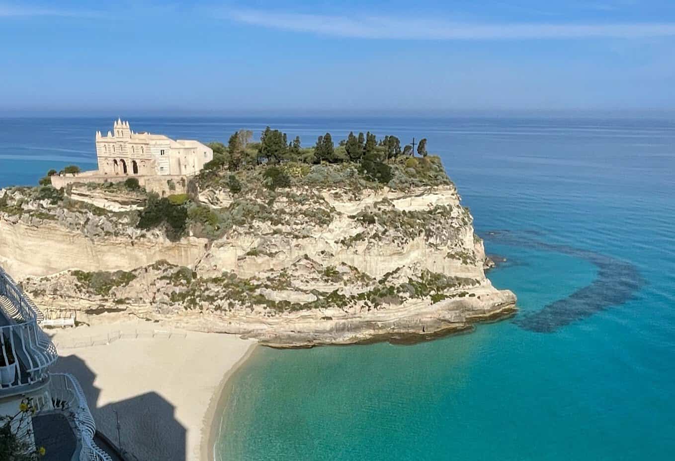 historic building on a cliff overlooking the turquoise sea in Tropea.