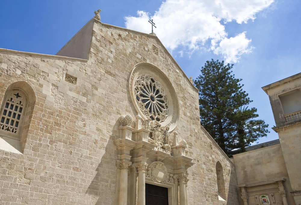 Historic Cathedral of Santa Maria Assunta in Otranto Puglia, Italy, featuring a detailed rose window, ornate stone facade, and religious sculptures.