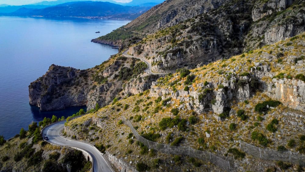aerial view of the coastline below from a winding coastal road in Sapri, Campania, Italy