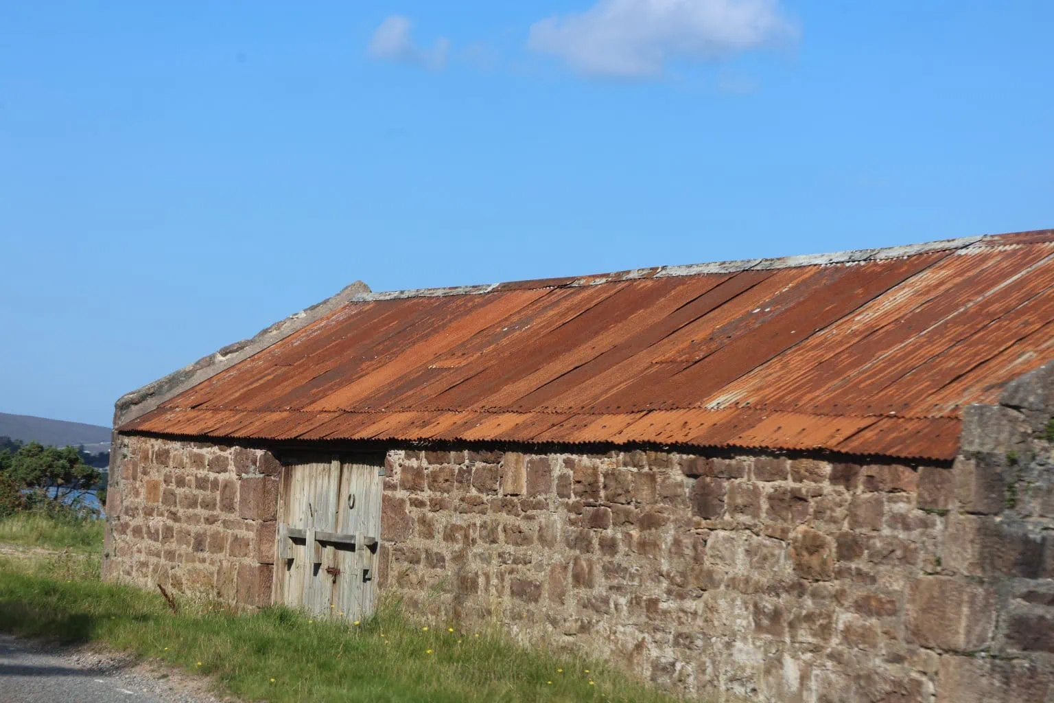 Old stone stedding with a rusty corrugated roof