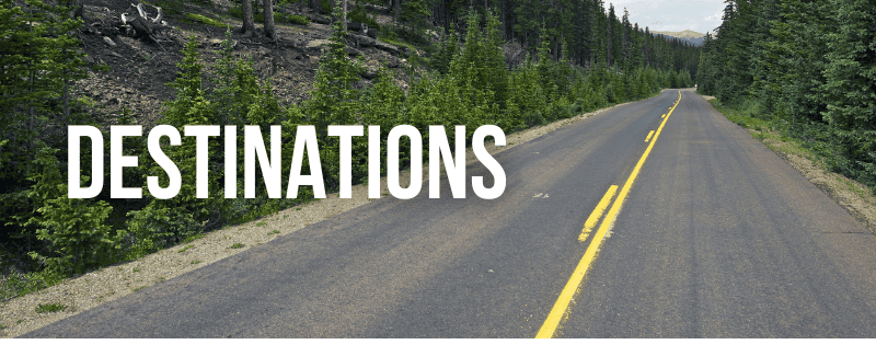 Open road through forest with "Destinations" overlay, inspiring travel adventures and road trip ideas for active, trendy grandparents.