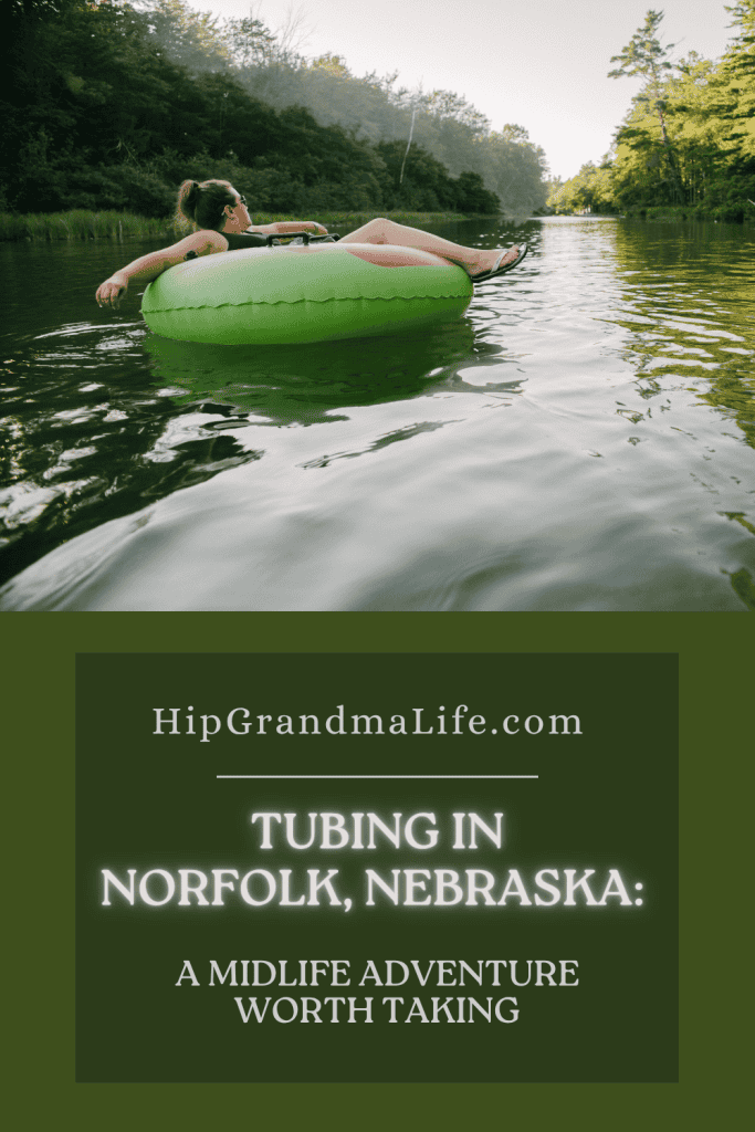 Woman tubing on a calm river surrounded by trees, with text overlay that reads ‘HipGrandmaLife.com – Tubing in Norfolk, Nebraska: A Midlife Adventure Worth Taking’ – promoting solo travel and outdoor experiences for women over 50.