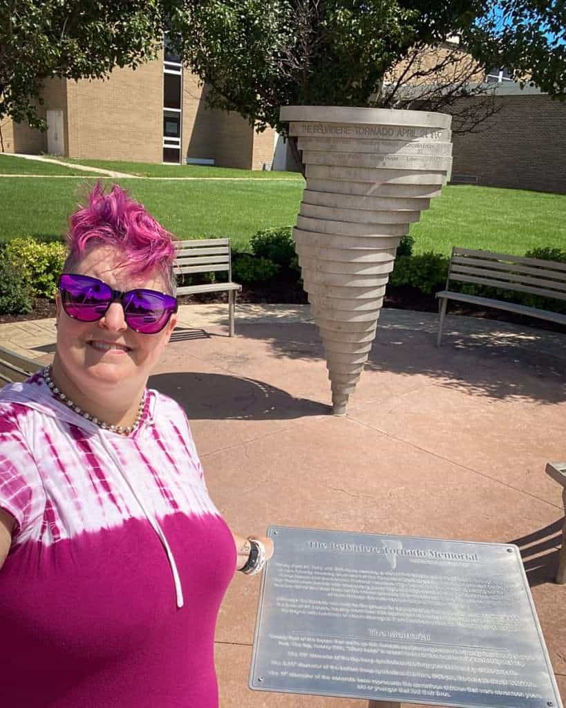 Hip Grandma stands in front of the Tornado Disaster Memorial in Belvidere showing one of the things to do in Northern Illinois.