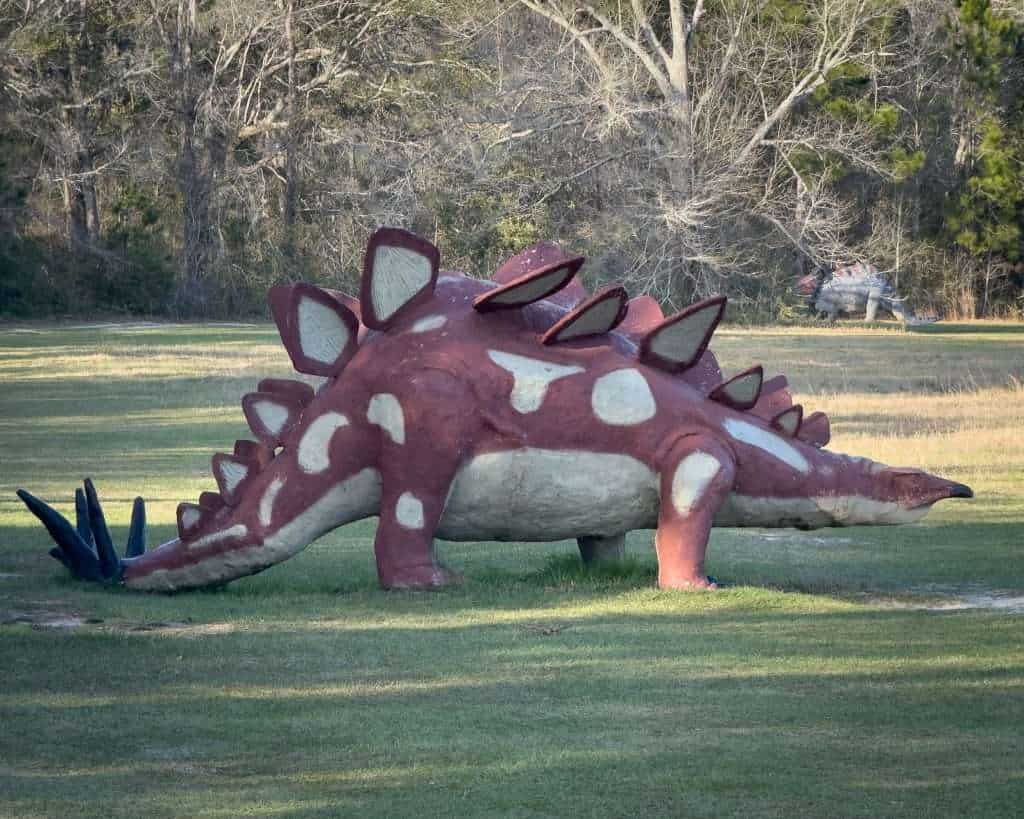 Large stegosaurus sculpture displayed in a grassy field at Barber Marina in Elberta, Alabama