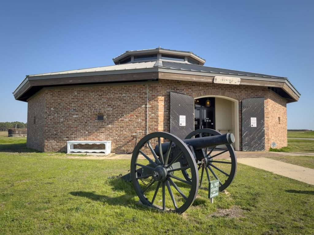 Historic cannon displayed outside the brick museum at Fort Morgan in Gulf Shores, Alabama