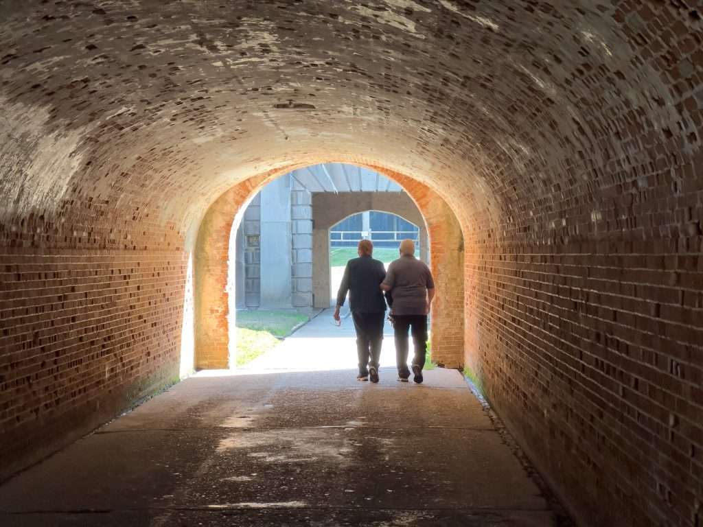 Visitors walking through a historic brick tunnel at Fort Morgan in Gulf Shores, Alabama