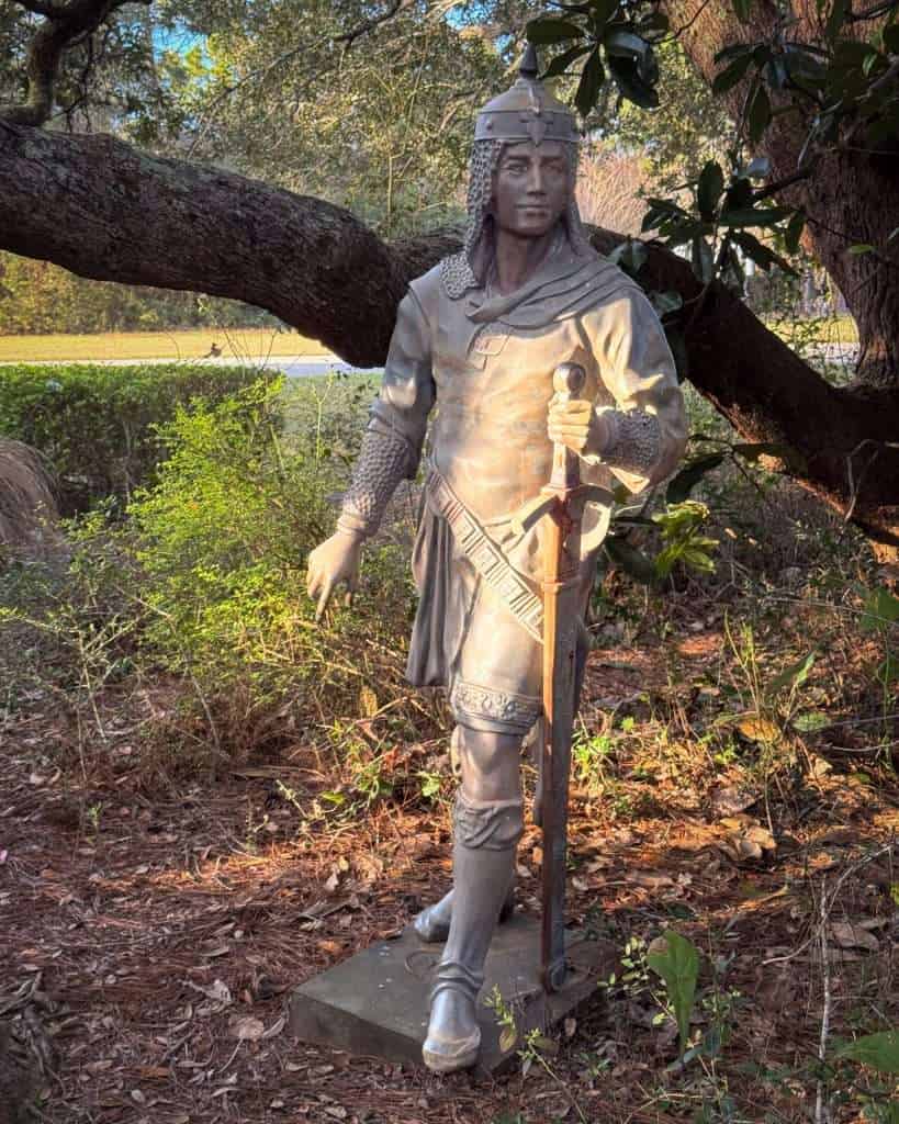 Fiberglass medieval knight sculpture standing along a wooded path at Barber Marina in Elberta, Alabama