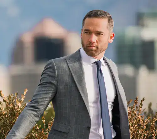 Professional businessman in a suit outdoors with city background.