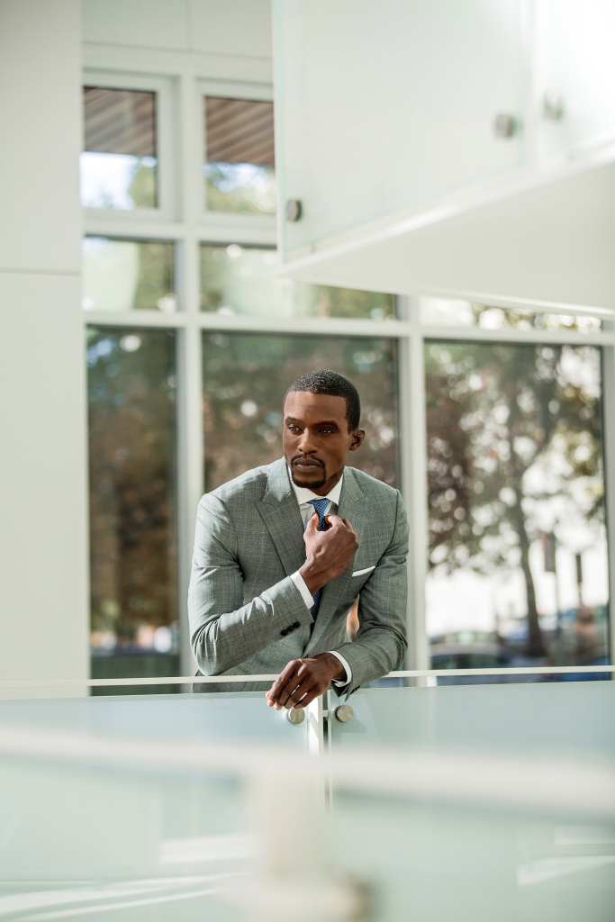 Confident businessman contemplating in a bright, modern office setting.