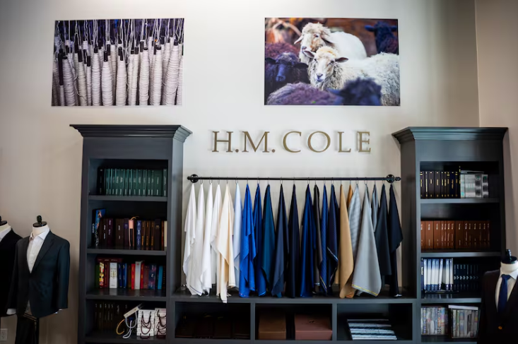 H.M. Cole store interior with fabric samples and clothing displays.
