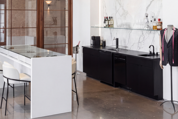 Modern bar area with black cabinetry and marble wall in a stylish venue.